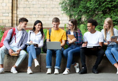 Happy teens preparing for exams in university campus 