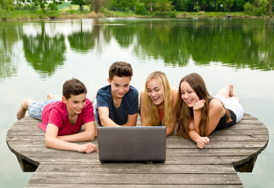 Group of teenagers with notebook outside in nature