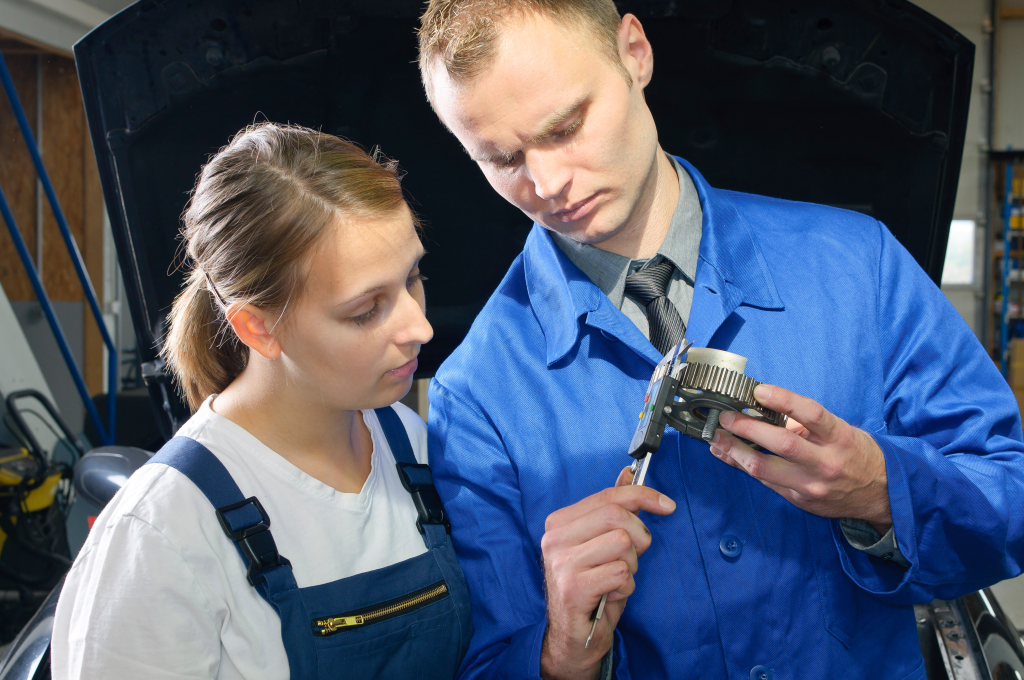 Car trainer and apprentice in the car workshop