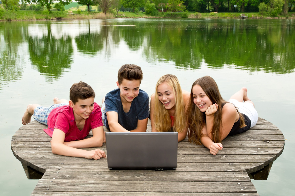 Group of teenagers with notebook outside in nature